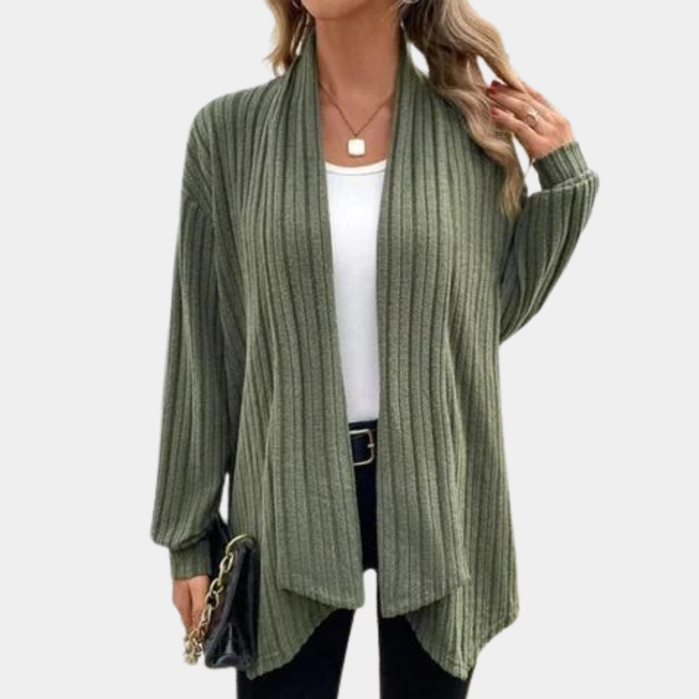Vrouw draagt een stijlvolle, geribbelde, legergroene cardigan over een witte top, gecombineerd met een zwarte broek en tas. Perfect voor casual mode.