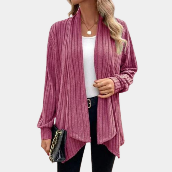 Roze gebreid damesvest, open voorkant, lange mouwen, casual stijl, gecombineerd met witte top en zwarte broek. Perfect voor herfstmode.
