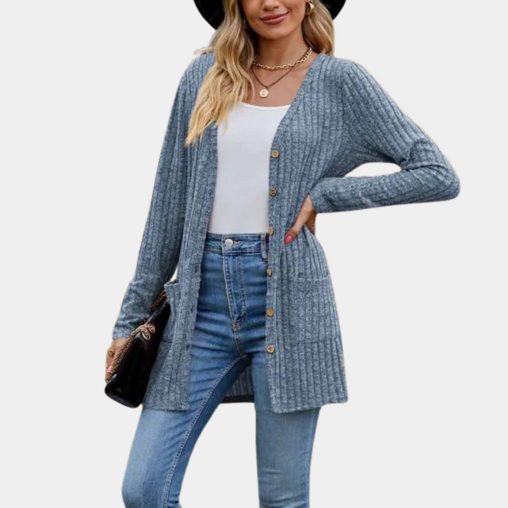 Vrouw draagt blauwe gebreide cardigan met knopen, witte top en jeans. Modieuze dameskleding, casual herfstoutfit, trendy stijl.
