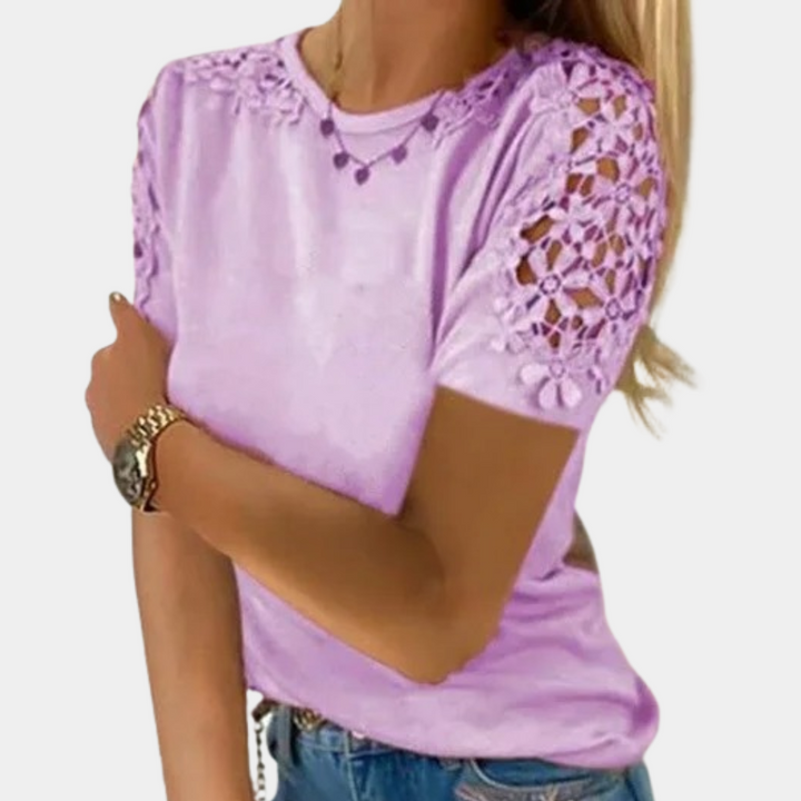 Vrouw draagt lila T-shirt met gehaakte bloemenmouwen, casual mode, trendy dameskleding, zomeroutfit, stijlvolle top, modieuze look.