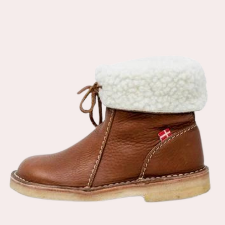 Bruine leren enkellaars met witte schapenvacht voering, vetersluiting en Deense vlag detail. Comfortabele winterlaars voor dames.