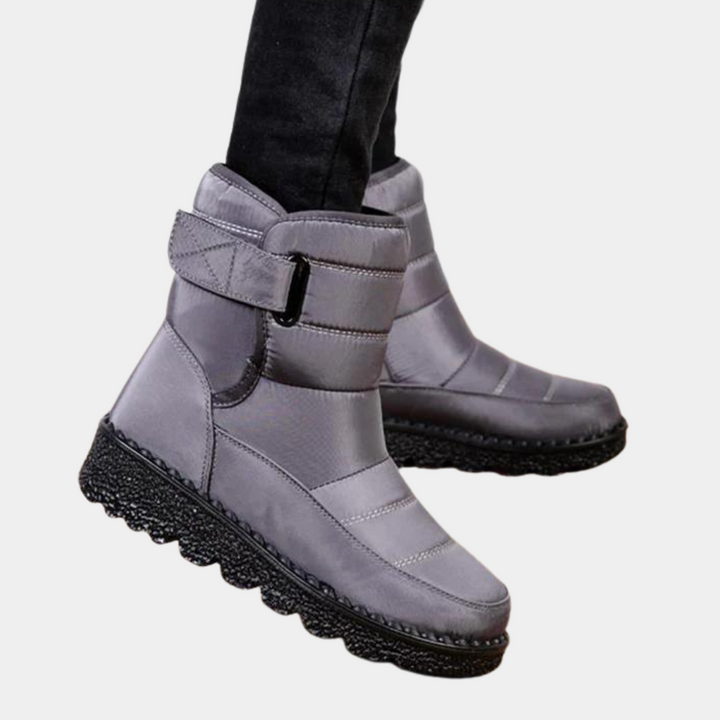 Grijze winterlaarzen met klittenbandsluiting, waterdicht en gevoerd, ideaal voor koude weersomstandigheden. Comfortabele en stijlvolle dameslaarzen.