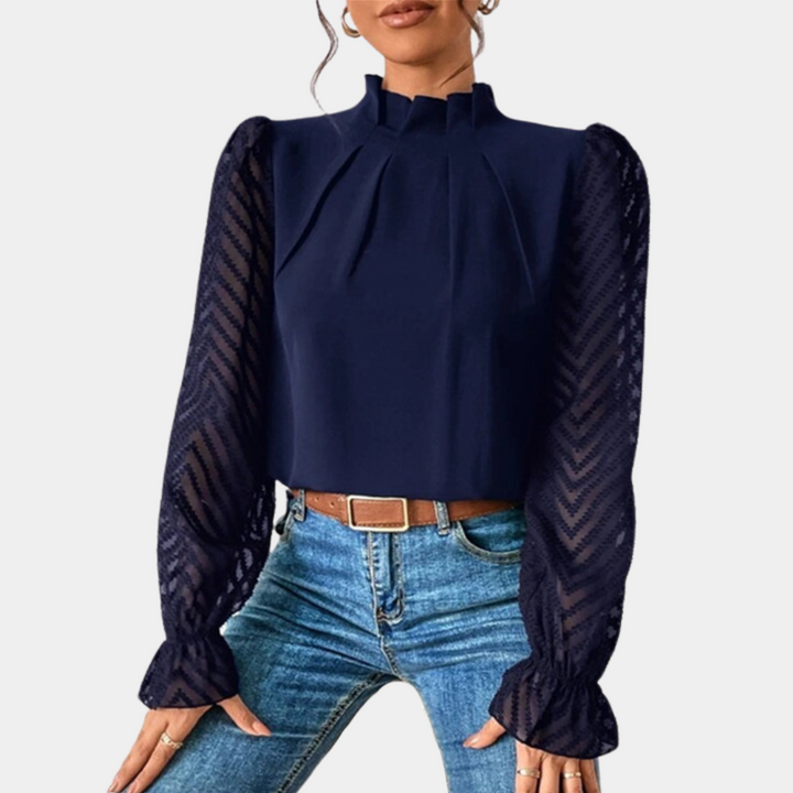 Donkerblauwe damesblouse met lange doorschijnende mouwen en hoge hals, gecombineerd met een bruine riem en blauwe jeans. Elegante mode.