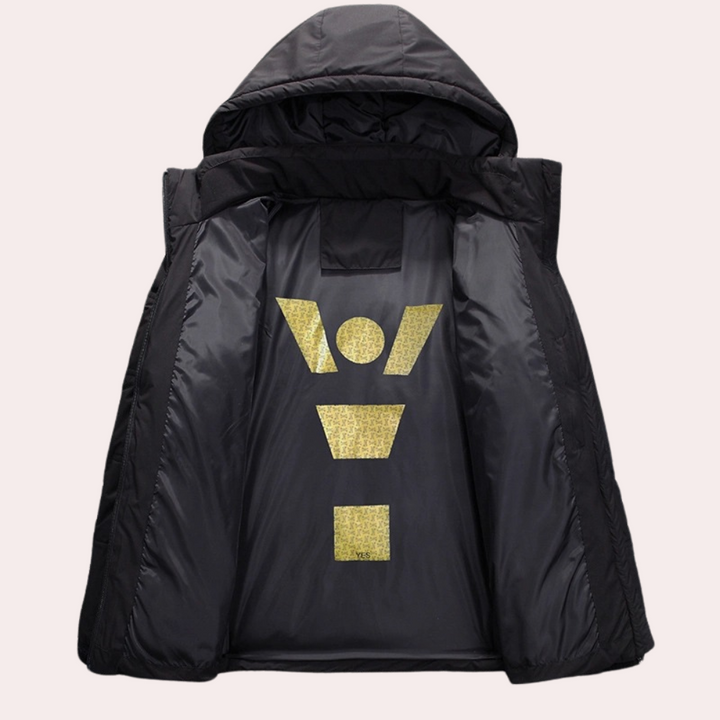 Zwarte gewatteerde jas met capuchon, opengeklapt om gouden geometrisch patroon aan de binnenkant te tonen. Stijlvolle winterjas voor heren.
