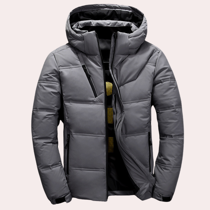 Donkergrijze gewatteerde winterjas met capuchon, ritssluiting en zakken. Stijlvolle herenjas voor koude seizoenen. Perfect voor outdoor activiteiten.
