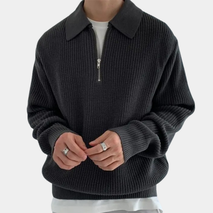 Zwarte gebreide trui met ritssluiting en kraag, gedragen door een persoon. Stijlvolle herenkleding, ideaal voor casual en formele gelegenheden.