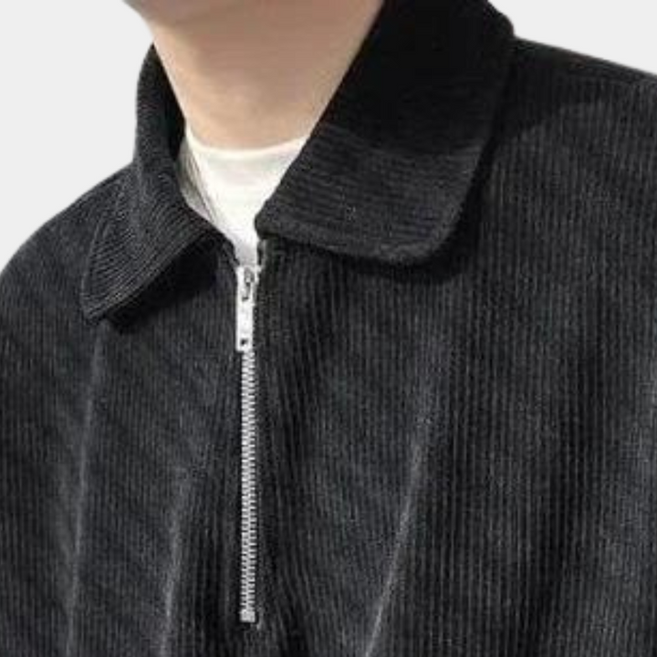 Zwarte corduroy jas met ritssluiting en kraag, gedragen door een persoon. Stijlvolle herenkleding, ideaal voor casual en formele gelegenheden.