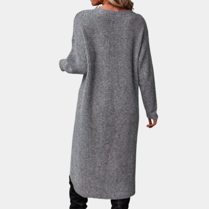 Grijze gebreide damesjurk met lange mouwen, knielengte, casual stijl. Perfect voor herfst- en wintermode. Comfortabel en stijlvol ontwerp.