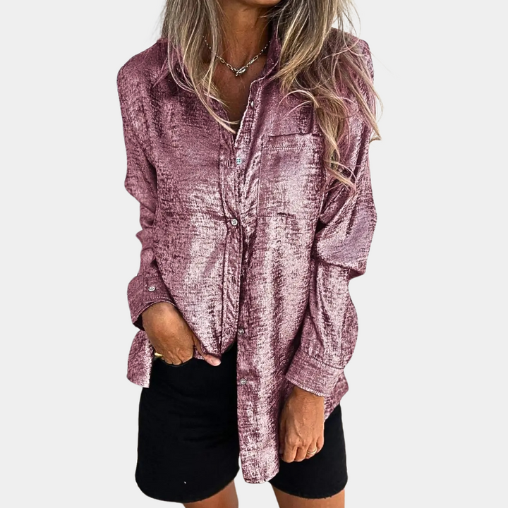 Vrouw draagt roze glanzende blouse met lange mouwen en zwarte rok. Modieuze dameskleding, trendy outfit, casual chique stijl.