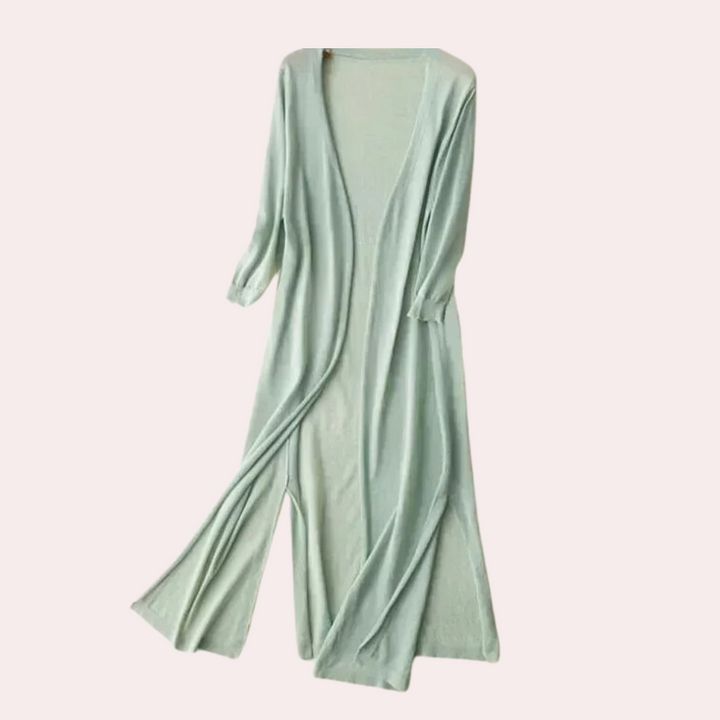 Lichtgroene damesjurk met lange mouwen, open voorkant en vloeiende stof. Perfect voor casual en elegante gelegenheden. Trendy modekleding.