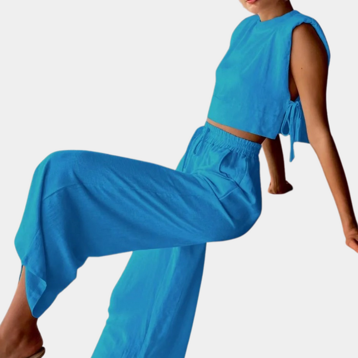 Vrouw in blauwe tweedelige outfit met mouwloos topje en wijde broek, modieuze zomerkleding, comfortabele casual stijl.