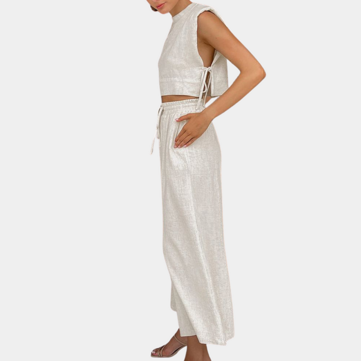 Vrouw in elegante, mouwloze khaki jumpsuit met wijde pijpen en strikdetail, modieuze dameskleding, zomeroutfit, zijaanzicht.