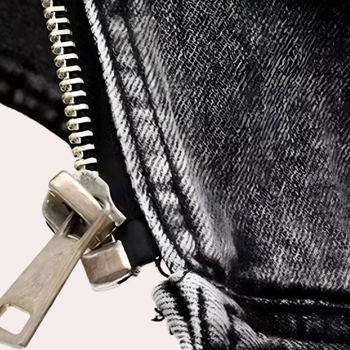 Zwarte spijkerbroek met metalen ritssluiting, close-up. Modieuze denim textuur, zilveren rits. Perfect voor casual en trendy outfits.