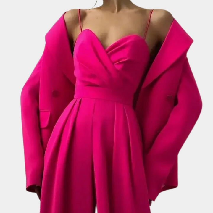 Vrouw in felroze jurk met spaghettibandjes en bijpassende oversized blazer. Trendy damesmode, elegante avondkleding, opvallende roze outfit.