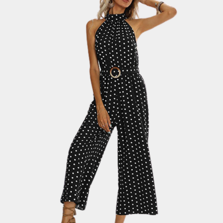 Zwarte jumpsuit met witte stippen, halternek en wijde pijpen. Trendy damesmode, perfect voor casual en chique gelegenheden.