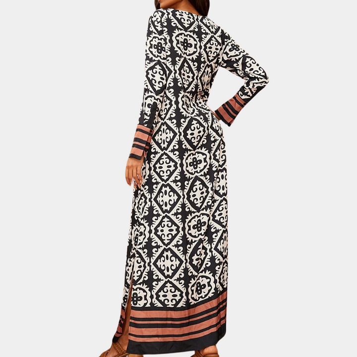 Zwart-witte maxi-jurk met lange mouwen en etnisch patroon, roze strepen aan de zoom. Perfect voor damesmode, bohemian stijl, casual elegantie.
