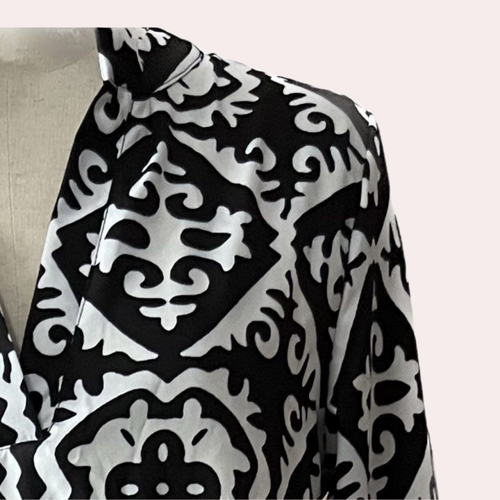 Zwart-witte blouse met geometrisch patroon, lange mouwen en kraag. Modieuze dameskleding, geschikt voor casual en zakelijke gelegenheden.