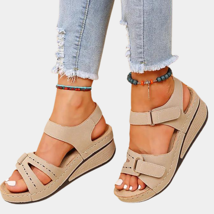 Beige sandalen met sleehak, verstelbare bandjes en open teen, gedragen met gerafelde jeans. Comfortabele zomerschoenen voor dames.