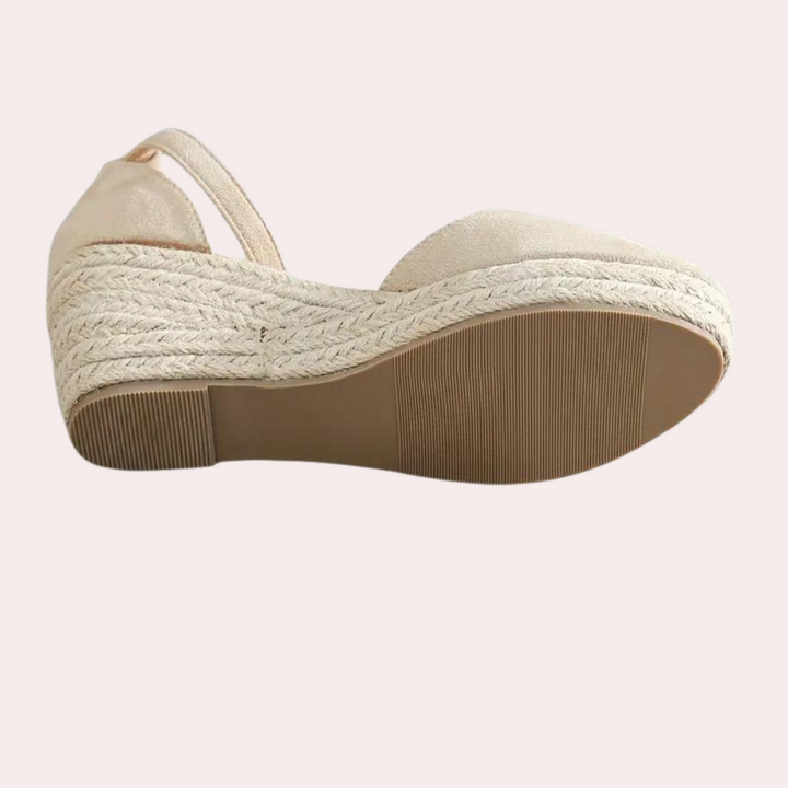 Beige espadrille wedge sandaal met gevlochten zool en open teen, zijaanzicht. Perfect voor zomermode en casual outfits.