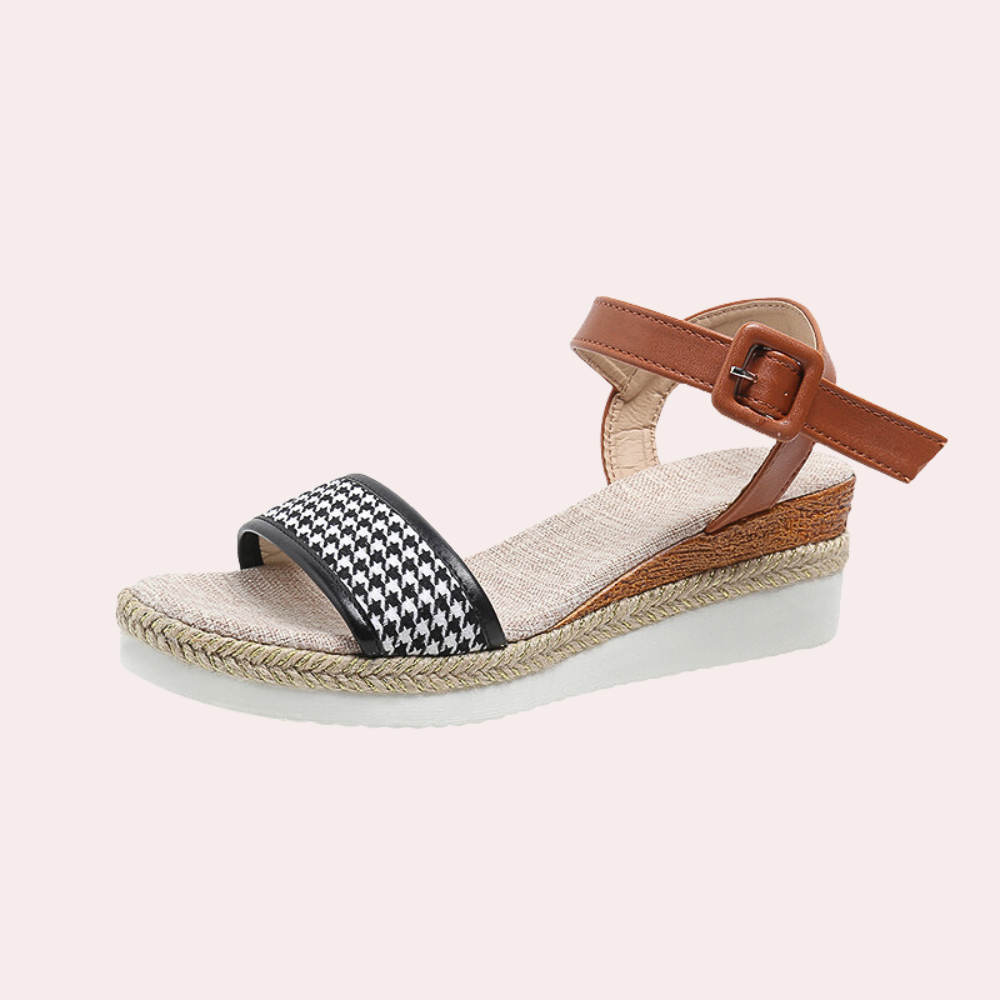 Zwarte dames sandaal met bruine enkelband, gevlochten zool en witte platformzool. Modieuze zomerschoen, ideaal voor casual en strandoutfits.