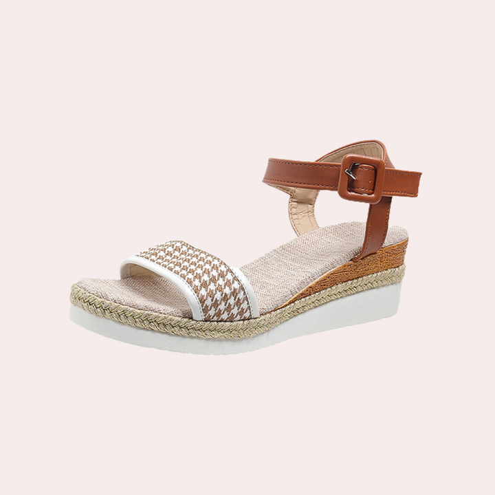 Witte dames espadrille sandaal met bruine leren enkelband, gevlochten zool en geweven voorband. Perfect voor zomerse outfits en casual stijl.