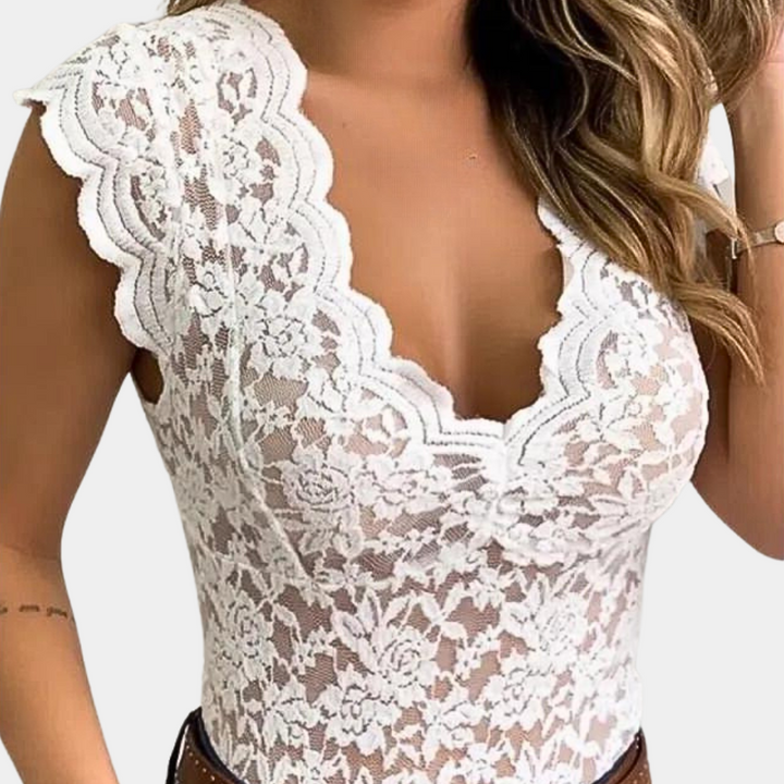 Vrouw draagt witte kanten top met bloemenpatroon en diepe V-hals, modieuze zomerkleding, elegant en stijlvol design.