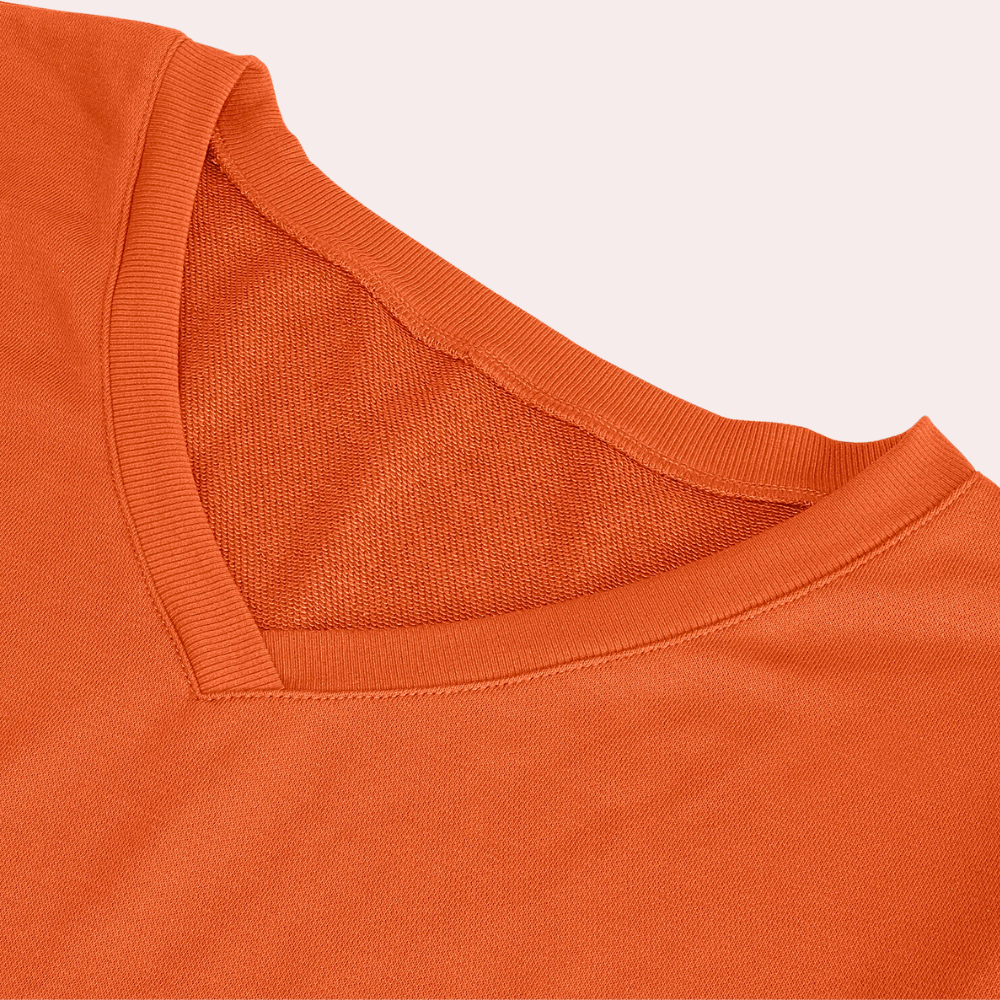 Oranje V-hals T-shirt van katoen, close-up van de kraag en stoftextuur. Comfortabel en stijlvol, perfect voor casual mode.