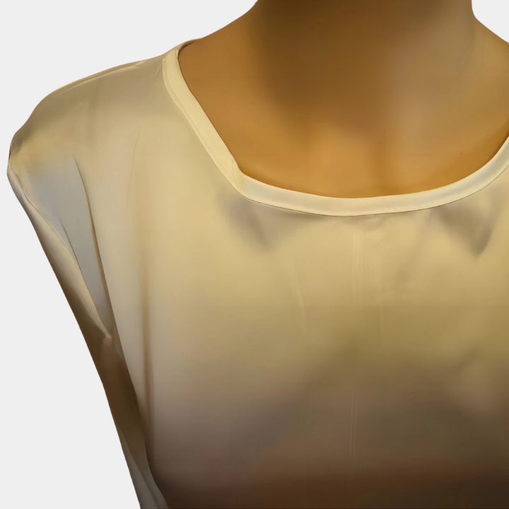 Witte damesblouse met ronde hals, mouwloos ontwerp. Elegante en minimalistische stijl, perfect voor zakelijke en casual outfits.