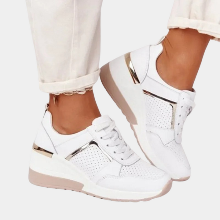 Witte dames sneakers met sleehak, perforaties en gouden accenten. Comfortabele en trendy schoenen voor dagelijks gebruik. Perfect voor casual outfits.