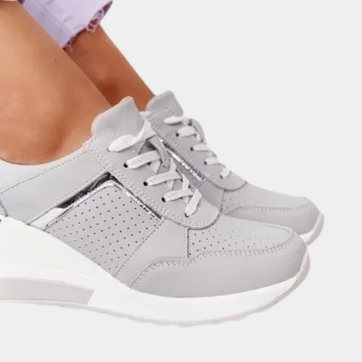 Grijze dames sneakers met witte zool, perforaties en veters. Comfortabele en modieuze schoenen voor dagelijks gebruik. Perfect voor casual outfits.
