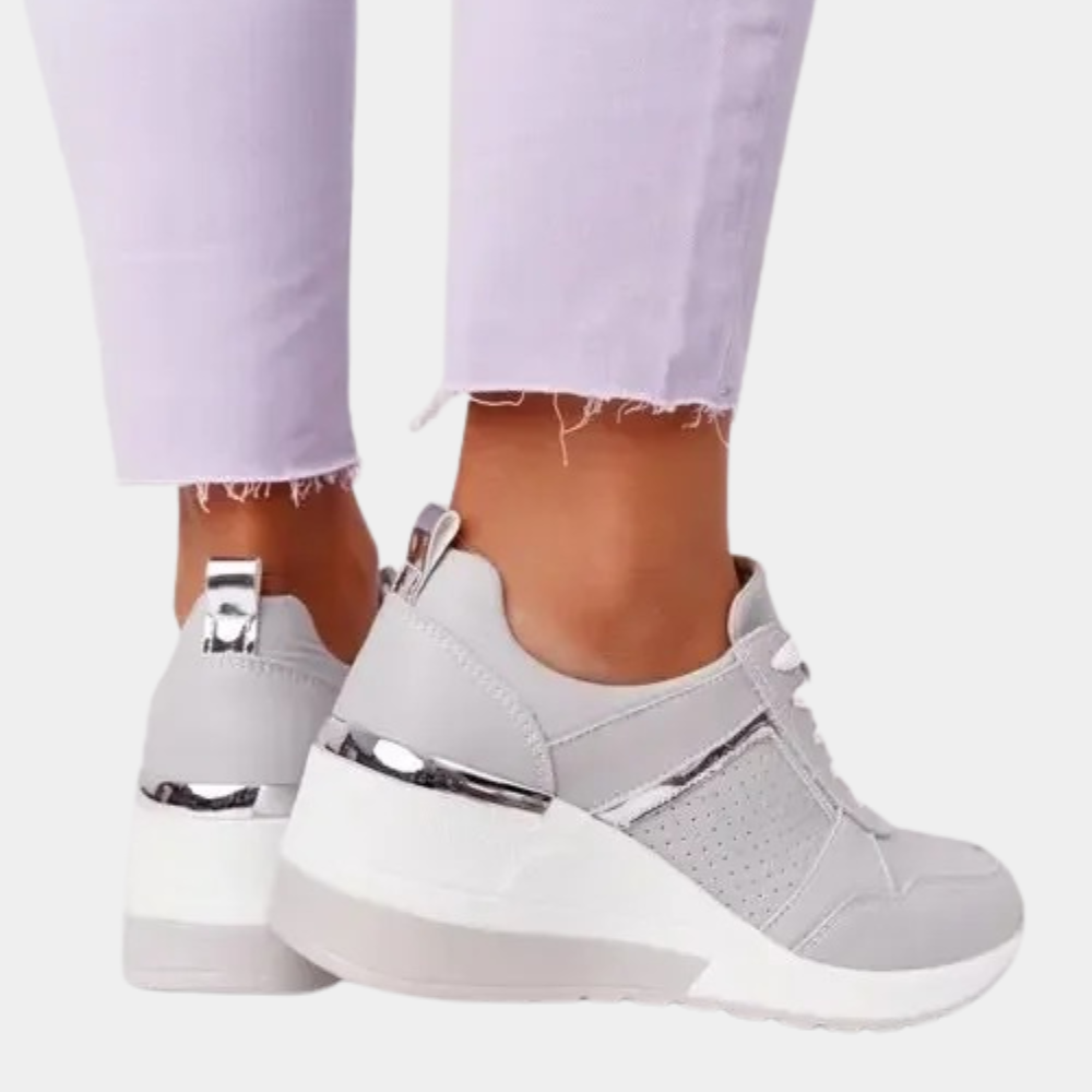 Witte dames sneakers met zilveren accenten en verhoogde zool, gedragen met lichtpaarse broek. Modieuze en comfortabele schoenen voor dagelijks gebruik.