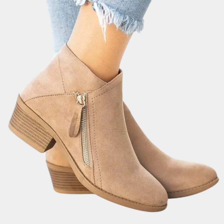 Beige enkellaarsjes met rits, lage hak en suède look, gedragen met lichtblauwe jeans. Stijlvolle damesmode, comfortabele herfstschoenen.