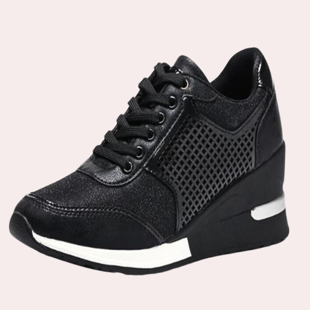 Zwarte damessneaker met sleehak, glanzend leer en gaasdetails. Comfortabele en modieuze schoenen voor dagelijks gebruik.
