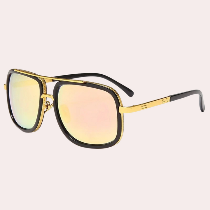 Gouden zonnebril met roze spiegelglazen en zwarte pootjes, modieuze unisex accessoire, luxe design, perfect voor zomerse stijl.