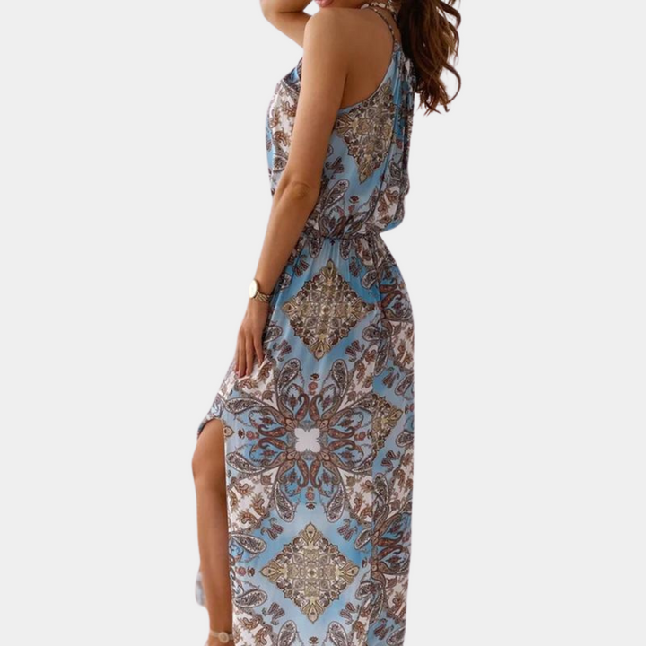 Vrouw in blauwe maxi-jurk met paisley-patroon, zijaanzicht. Zomermode, elegante dameskleding, bohemian stijl, casual chique outfit.