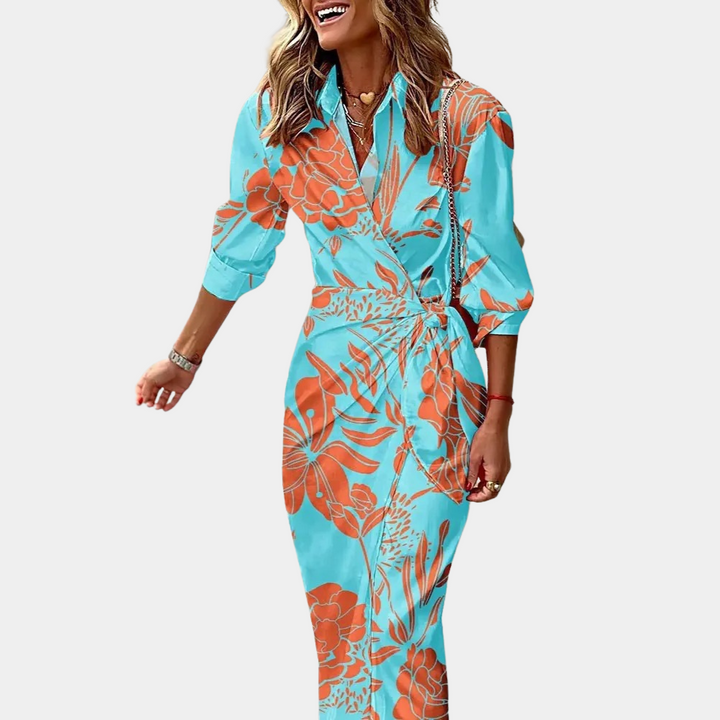 Vrouw in lichtblauwe jurk met oranje bloemenprint, driekwart mouwen en V-hals. Trendy damesmode, zomerjurk, casual elegantie.
