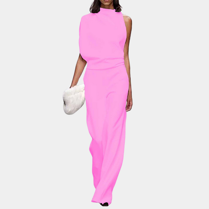 Vrouw in felroze asymmetrische jumpsuit met witte clutch, modieuze outfit, trendy dameskleding, elegante avondlook, modeaccessoire.