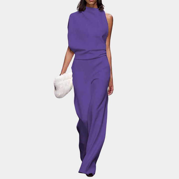 Paarse asymmetrische damesjurk met hoge hals en wijde pijpen, gecombineerd met een witte clutch. Elegante avondmode, trendy en stijlvol.