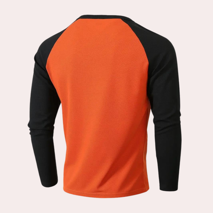 Oranje en zwart heren sportshirt met lange mouwen, raglanstijl. Ideaal voor hardlopen en fitness. Comfortabel en ademend materiaal.
