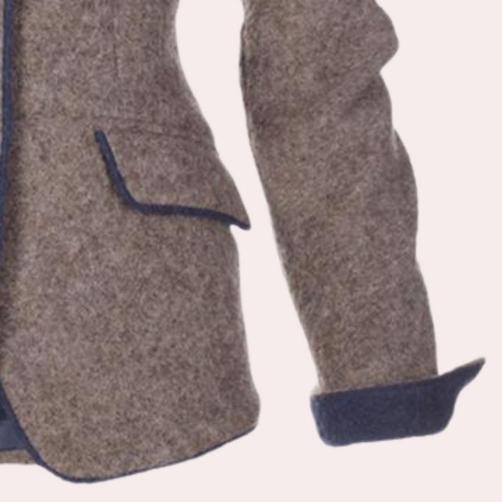 Bruine wollen blazer met blauwe accenten, opgestoken mouwen en klepzakken. Stijlvolle damesjas voor herfstmode.