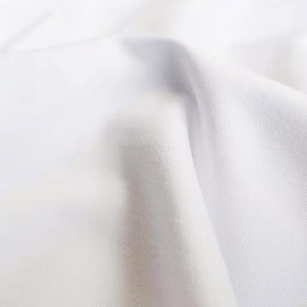 Witte katoenen stof close-up, gladde textuur, geschikt voor kleding en interieur, hoogwaardige kwaliteit, duurzaam en ademend materiaal.