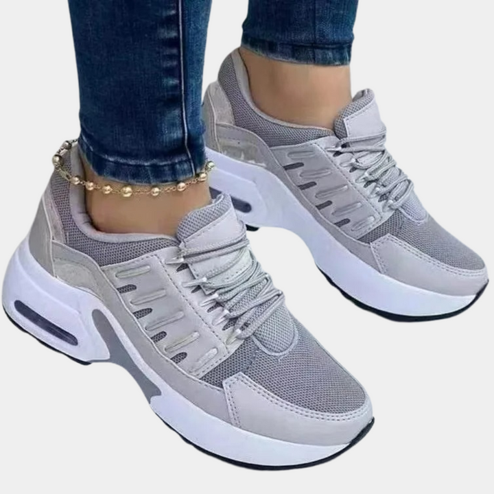 Grijze dames sneakers met dikke zool, ademend mesh en leren details. Comfortabele sportschoenen, ideaal voor dagelijks gebruik en casual outfits.