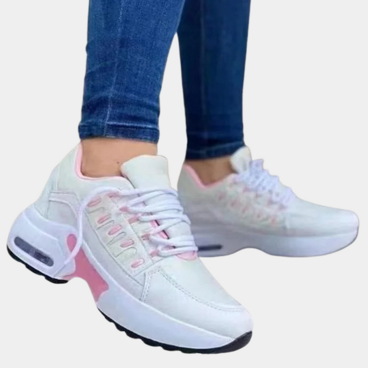 Witte dames sneakers met roze accenten, dikke zool en veters. Comfortabele sportschoenen voor dagelijks gebruik. Trendy en stijlvol design.