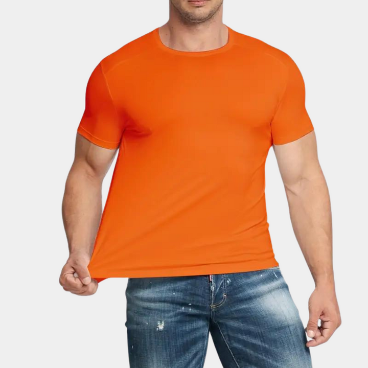 Oranje heren T-shirt, korte mouwen, gedragen door man, casual stijl, gecombineerd met blauwe jeans. Perfect voor zomerse mode en sportieve looks.