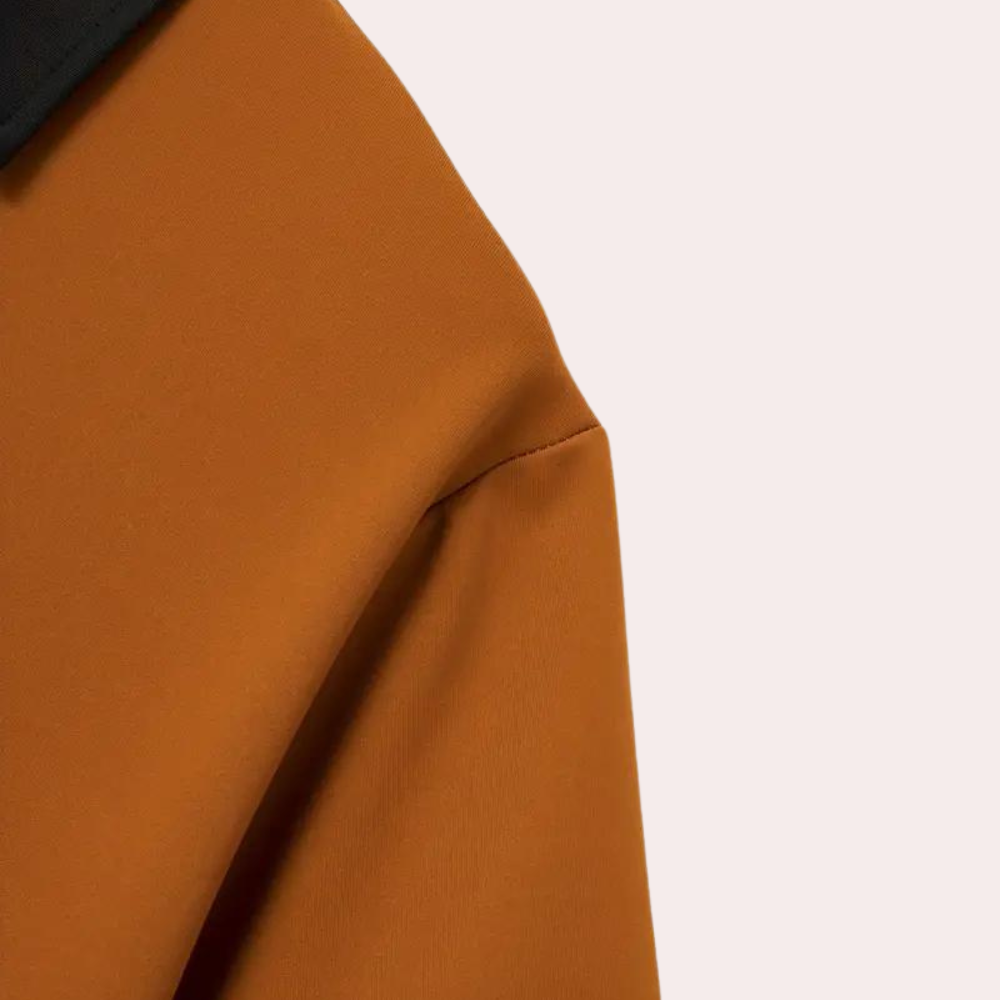 Oranje jas met zwarte kraag, minimalistisch design, hoogwaardige stof. Perfect voor herfstmode, stijlvolle en moderne uitstraling.