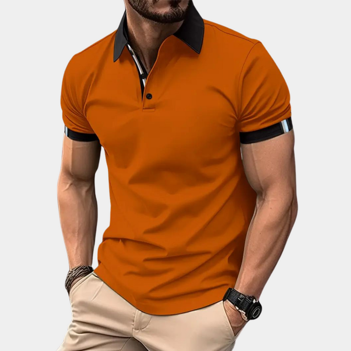 Oranje polo shirt voor heren met zwarte kraag en mouwdetails, gedragen door een man. Stijlvolle casual herenkleding, modetrend 2023.