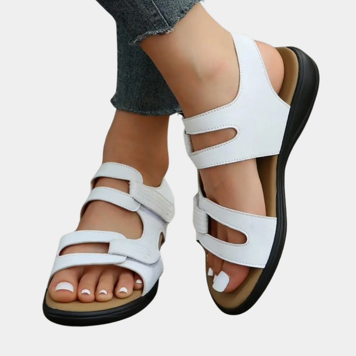 Witte dames sandalen met klittenbandsluiting, comfortabele zool, gedragen met jeans. Perfect voor zomerse casual outfits en dagelijks gebruik.