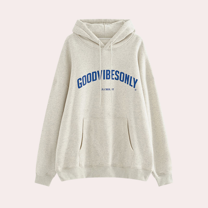 Beige hoodie met capuchon en buidelzak, bedrukt met "GOOD VIBES ONLY" in blauwe letters. Comfortabele, casual kleding voor dagelijks gebruik.