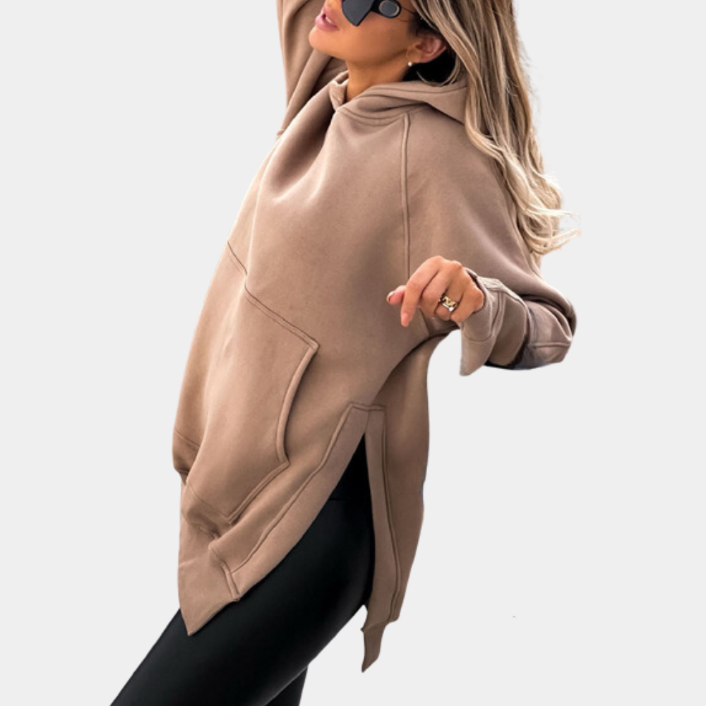 Vrouw in khaki oversized hoodie met capuchon en zwarte legging, modieuze herfstkleding, comfortabele streetwear, casual stijl.
