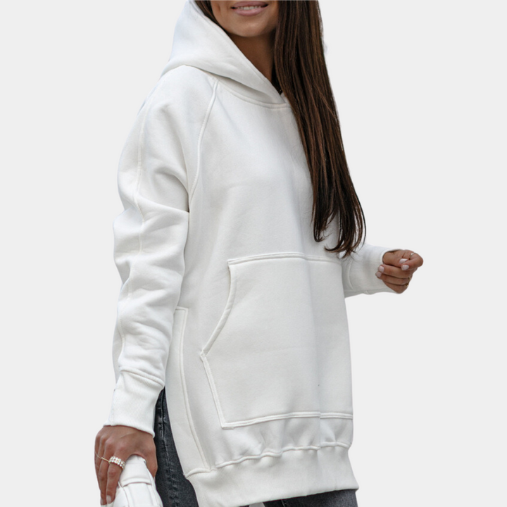 Vrouw in witte oversized hoodie met capuchon, casual streetwear, comfortabele mode, lange mouwen, grote zak, trendy kledingstijl.